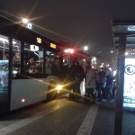 Fahrgäste steigen in einen Bus bei Nacht.