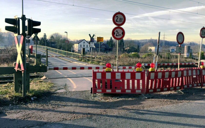 Barrieren vor der Brücke mit Bahnübergang